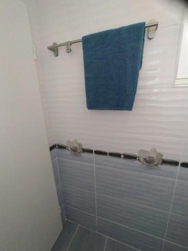 uma casa de banho com um chuveiro e uma toalha azul em Апартамент White apartment град Китен em Kiten