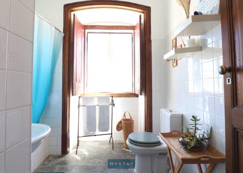 La salle de bains est pourvue de toilettes et d'une fenêtre. dans l'établissement MyStay - Mértola Castelo Palace, à Mértola