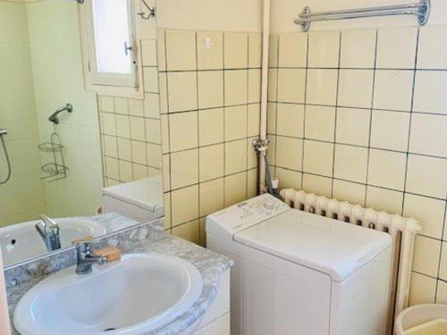 La petite salle de bains est pourvue d'un lavabo et d'un lave-linge. dans l'établissement F2 Meublé avec Clim et WIFI à Amélie-les-Bains - FR-1-703-149, à Amélie-les-Bains-Palalda