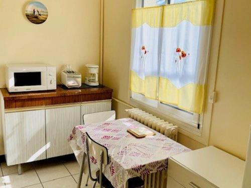 une petite cuisine avec une table et un micro-ondes dans l'établissement F2 Meublé avec Clim et WIFI à Amélie-les-Bains - FR-1-703-149, à Amélie-les-Bains-Palalda
