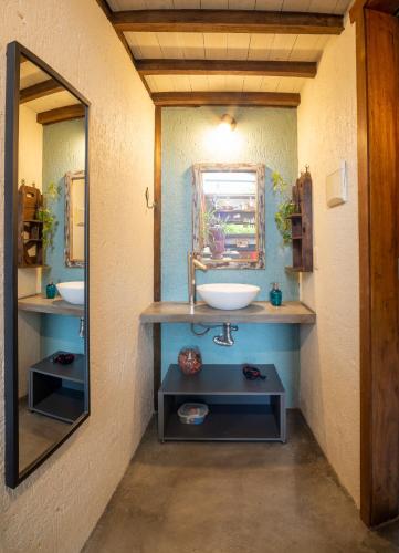 a bathroom with a sink and a mirror at Casinha Jardim in Imbituba