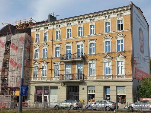 a large building with cars parked in front of it at Trzynastka in Chorzów