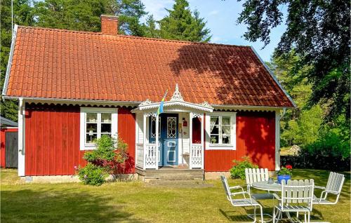 a red and white house with a table and chairs at Awesome Home In Löttorp With Kitchen in Löttorp