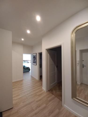 an empty room with a mirror and a hallway at Trzynastka in Chorzów