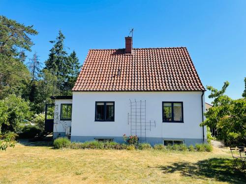 uma casa branca com um telhado vermelho num campo em Large house with sea view em Kivik