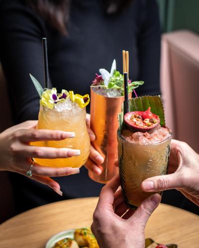 a group of people holding up three drinks on a table at St. James' Court, A Taj Hotel, London in London