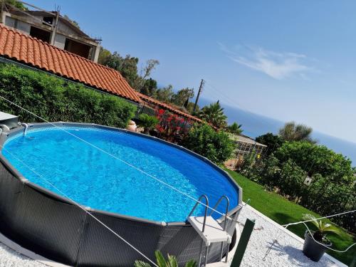 una grande piscina blu accanto a una casa di Le 4 stagioni, appartamento in Villa a Bordighera