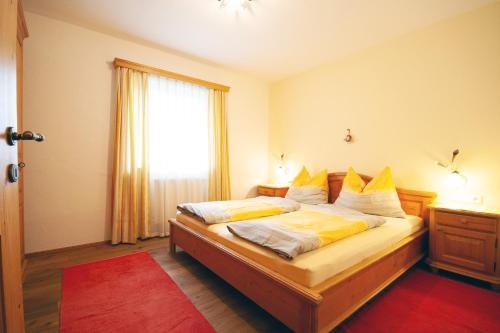 Almliesl GOLD-705 في Maierhof: غرفة نوم بسرير مع مخدات صفراء وبيضاء