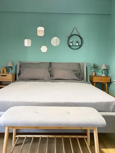 1 dormitorio con 1 cama con pared azul en Πολυτέλεια και ηρεμία στο κέντρο των Β.Προαστίων.., en Atenas