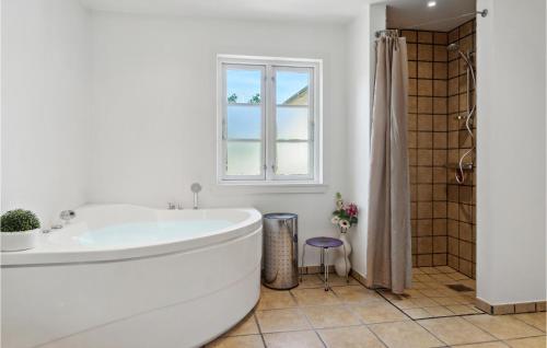 Højbyにある3 Bedroom Stunning Home In Hjbyの白いバスルーム(バスタブ付)、窓が備わります。