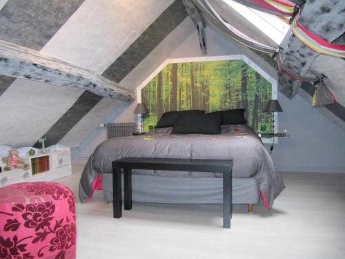 ein Schlafzimmer mit einem Bett und einem großen Fenster in der Unterkunft La Roseraie du Prieure in Rosay-sur-Lieure