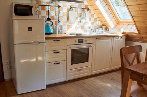 a kitchen with a white refrigerator and a sink at Chata Harmonie in Bedřichov