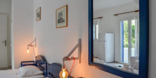 a mirror in a room with a bed and a refrigerator at Almira Studios in Kionia