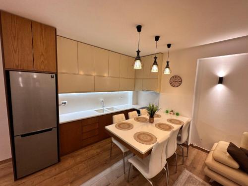 446 Luxury Apartament Center في شكودر: مطبخ مع طاولة ومغسلة وثلاجة