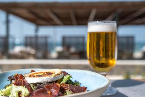 a plate of food and a glass of beer at Cádiz Bahía by QHotels in Cádiz