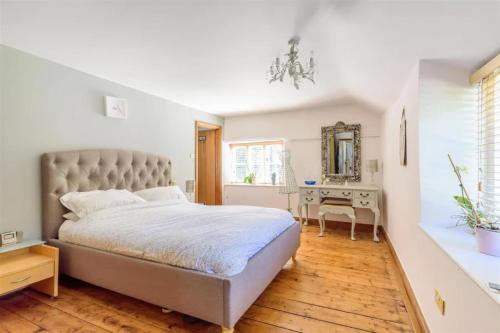 a bedroom with a large bed and a desk at Berehayes Farmhouse in Bridport