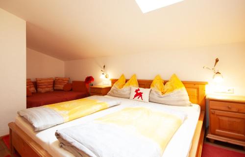 a bedroom with a large bed with yellow pillows at Almliesl GOLD-705 in Maierhof