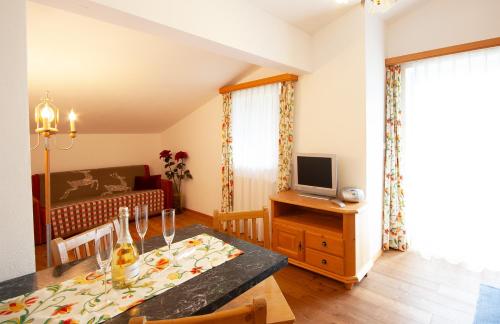 a living room with a dining table and a television at Almliesl GOLD-705 in Maierhof