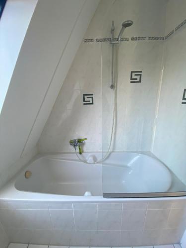a bathroom with a bath tub with a shower at Noordwijk Holiday Rentals in Noordwijk