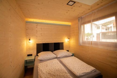 a small bedroom with a bed and a window at Camp Ante-Gojko in Grebaštica