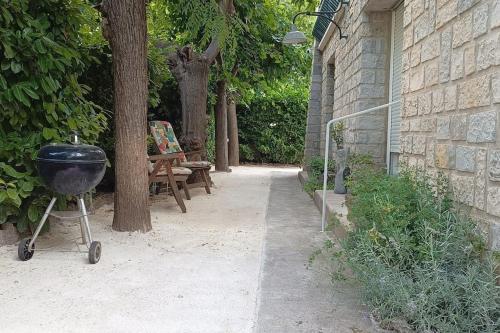 a barbecue grill on a cart next to a building at Grand appartement, 2 chambres et jardin in Nîmes