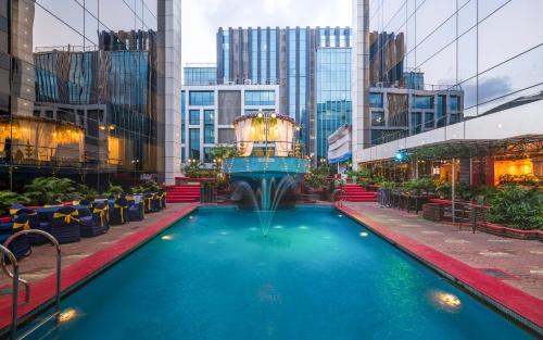 a pool with a fountain in the middle of a city at Hotel Kohinoor Continental,Airport in Mumbai