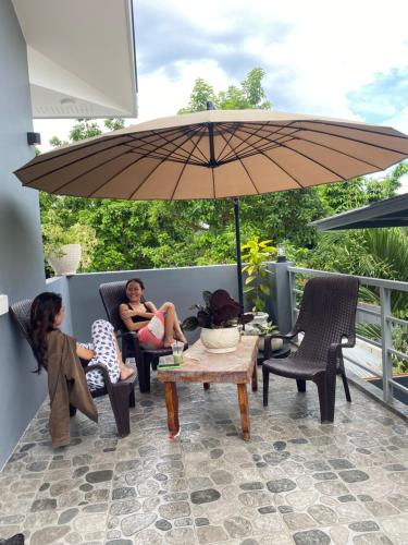 two women sitting on a patio under an umbrella at Hai Inn in Dumaguete