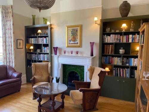 a living room with a fireplace and bookshelves at Hamilton Lodge: a 6 bedroom seaside Holiday Home hosting Happiness in Kent