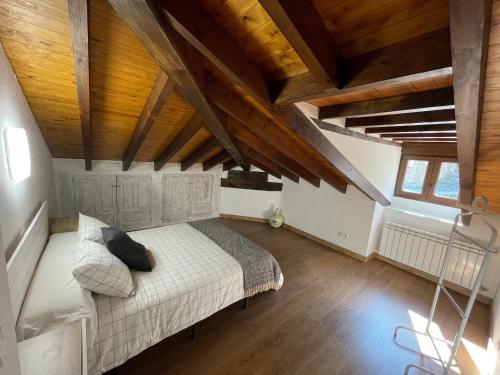 1 dormitorio con 1 cama en una habitación con techos de madera en Apartamento Cabariezo, en Cabezón de Liébana