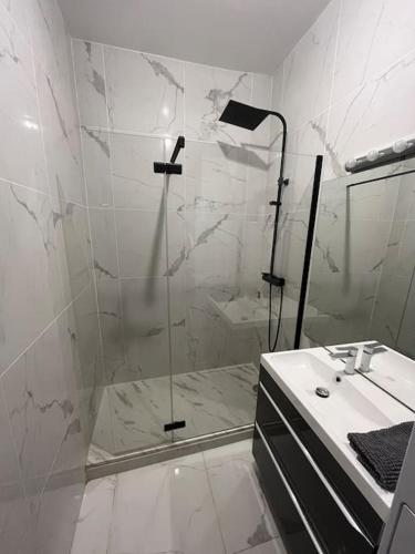 une salle de bain blanche avec une douche et un lavabo dans l'établissement Ô Toulouse, à Toulouse