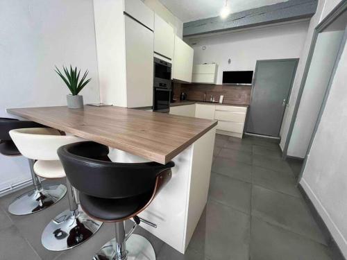 - une cuisine avec un comptoir en bois et des tabourets dans l'établissement Ô Toulouse, à Toulouse