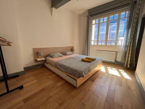 une chambre avec un lit et une grande fenêtre dans l'établissement Ô Toulouse, à Toulouse
