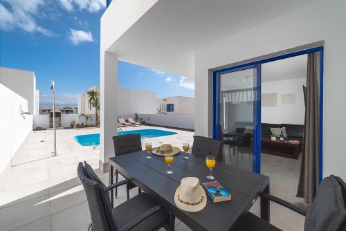 a dining room with a table and chairs and a pool at Villas Yaiza in Playa Blanca