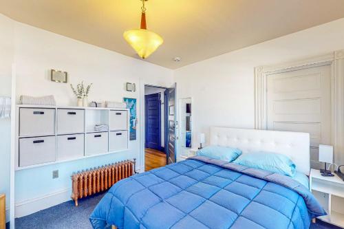 een slaapkamer met een blauw bed in een kamer bij A Little Piece of History in Boston