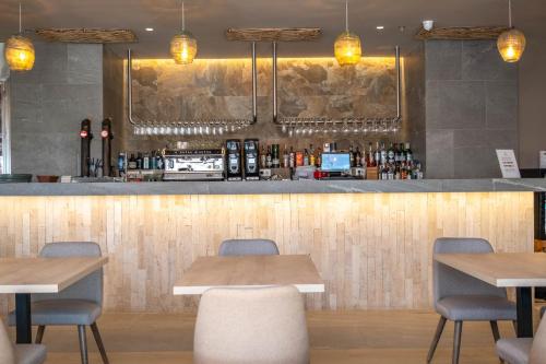 a bar in a restaurant with tables and chairs at Cádiz Bahía by QHotels in Cádiz