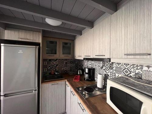 a kitchen with a stainless steel refrigerator and wooden cabinets at Traditional house in the heart of Naxos in Dhamariónas