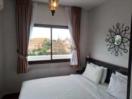 ein Schlafzimmer mit einem weißen Bett und einem Fenster in der Unterkunft Chetuphon Gate in Bangkok