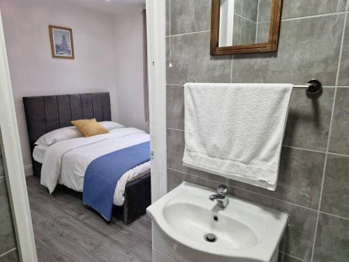 a bathroom with a sink and a bed at Starlet Property in Wanstead