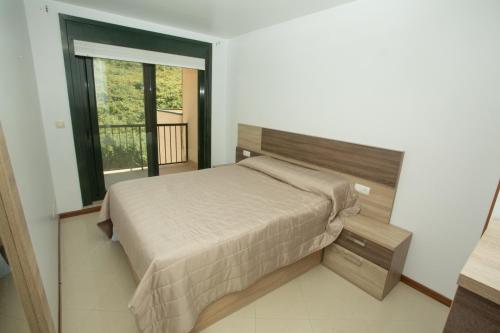 a bedroom with a bed and a large window at El Pommier in Fisterra