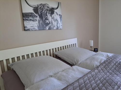 ein Bett mit einem Bild eines Stiers an der Wand in der Unterkunft Mutti ´s Landhof 