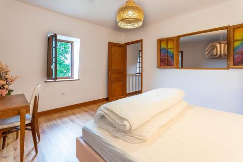 1 dormitorio con cama, mesa y ventana en Lou Grit - Maison pour 10 avec piscine privée, en Salies-de-Béarn