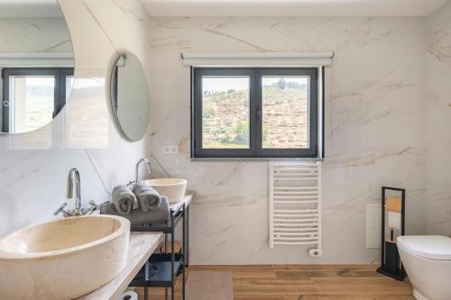 a bathroom with two sinks and a toilet at Cottage Douro Vallée 