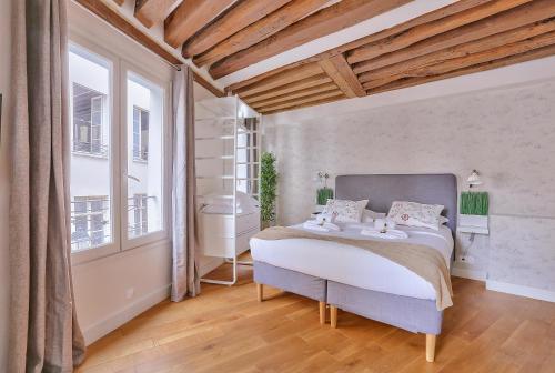 a bedroom with a bed and a large window at St Michel - Deluxe Apartment - Harpe in Paris