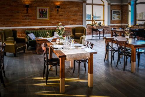 a restaurant with tables and chairs and a brick wall at Folwark Łękuk in Łękuk Mały