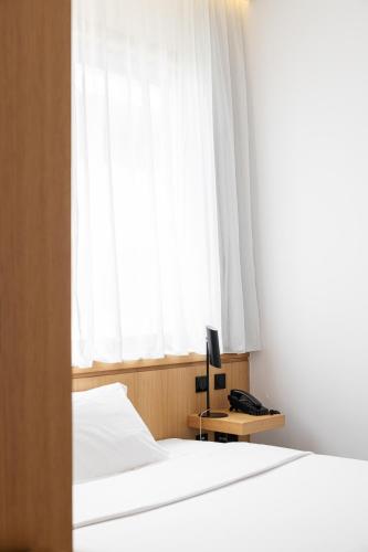 a bedroom with two beds and a window at Evora Olive Hotel in Évora