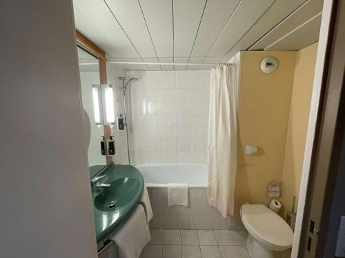 a bathroom with a sink and a tub and a toilet at ibis Epinal Centre in Épinal