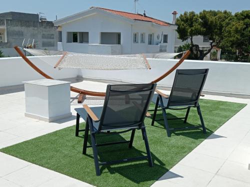 dwa krzesła i stół na dachu w obiekcie Aegean Breeze Beach House w mieście Artemida