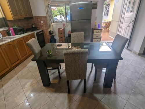 a kitchen with a table and chairs and a refrigerator at Λευτέρης in Isthmia