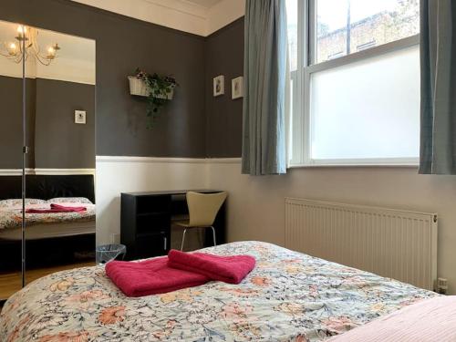 - une chambre avec un lit et une serviette rouge dans l'établissement Keysan House 1, à Londres