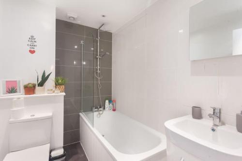 La salle de bains est pourvue d'une douche, d'une baignoire et d'un lavabo. dans l'établissement Keysan House 1, à Londres